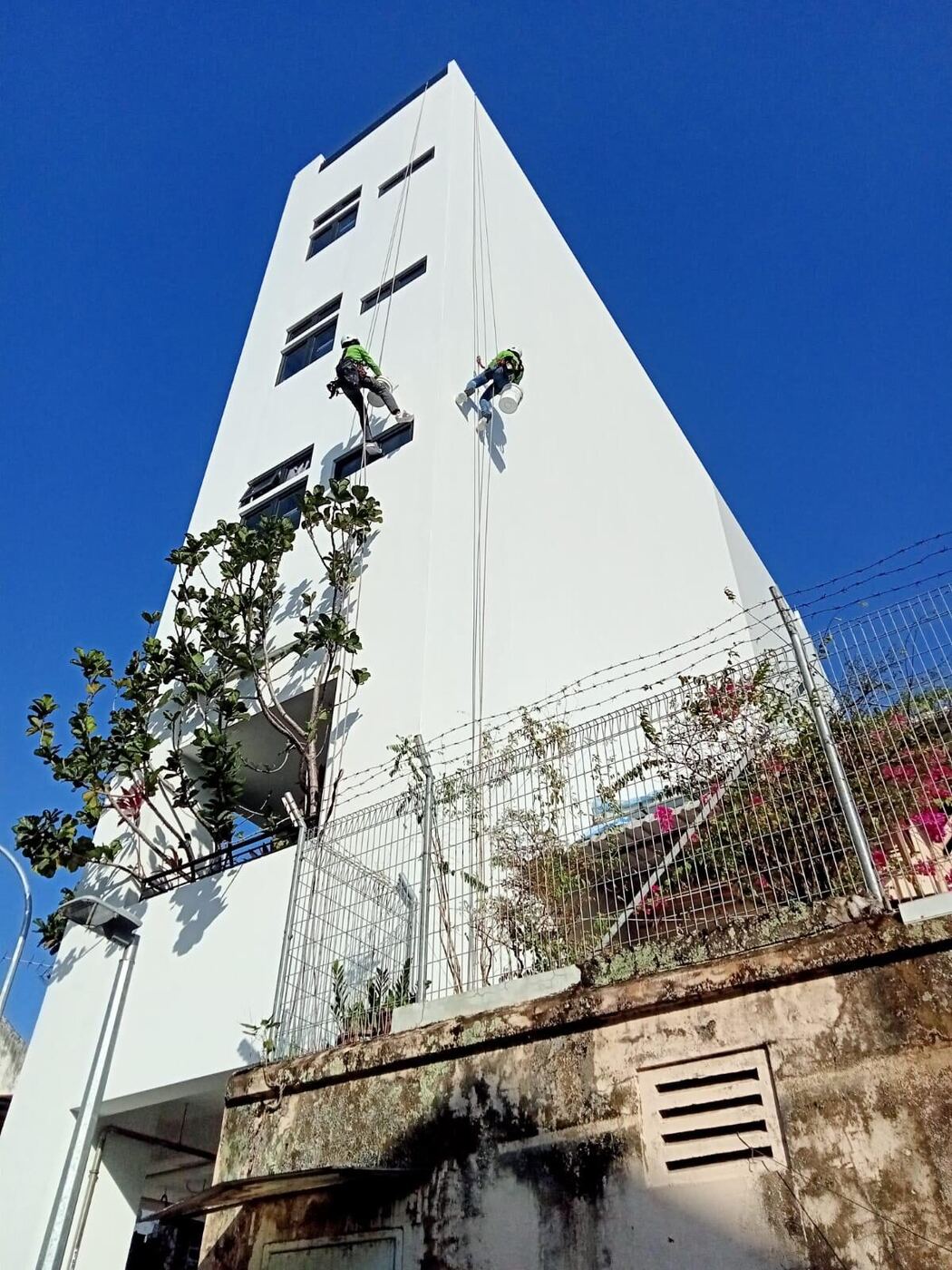 Façade wall repair and repainting access using rope access methods