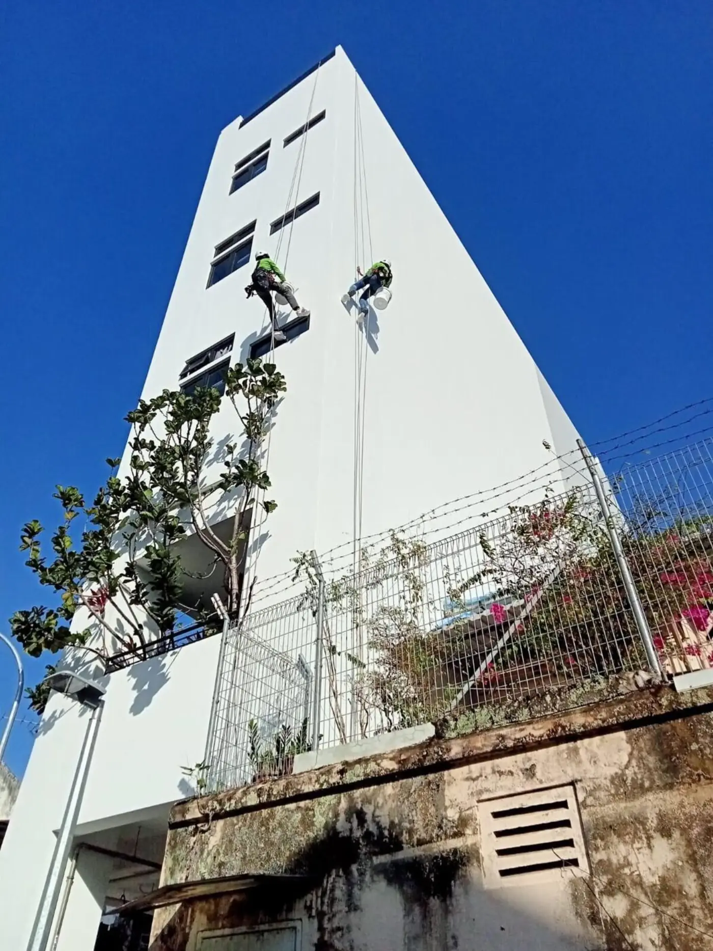Façade wall repair and repainting access using rope access methods