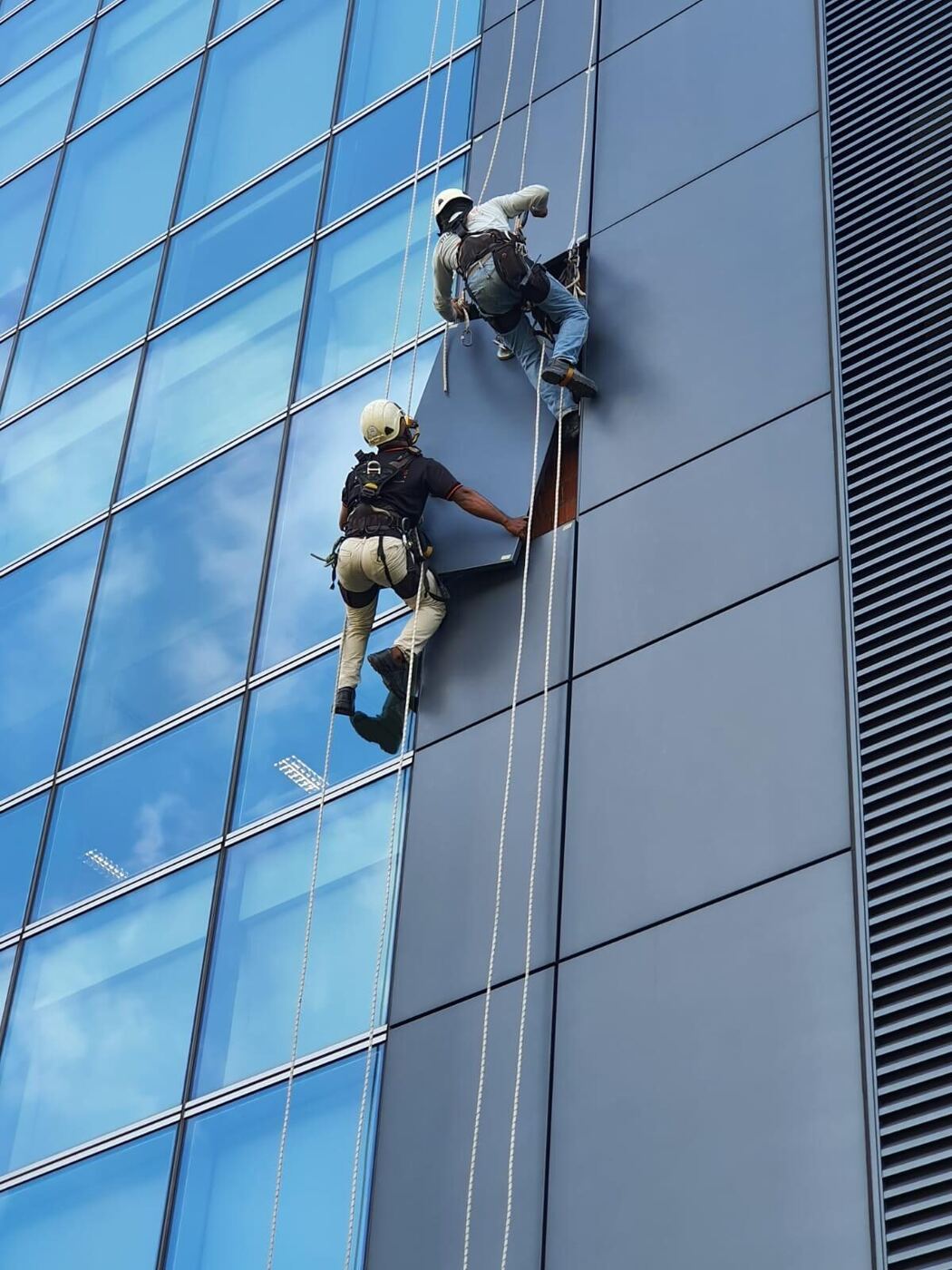 Rope access team on a high-rise building reviewing safety set-up in Singapore