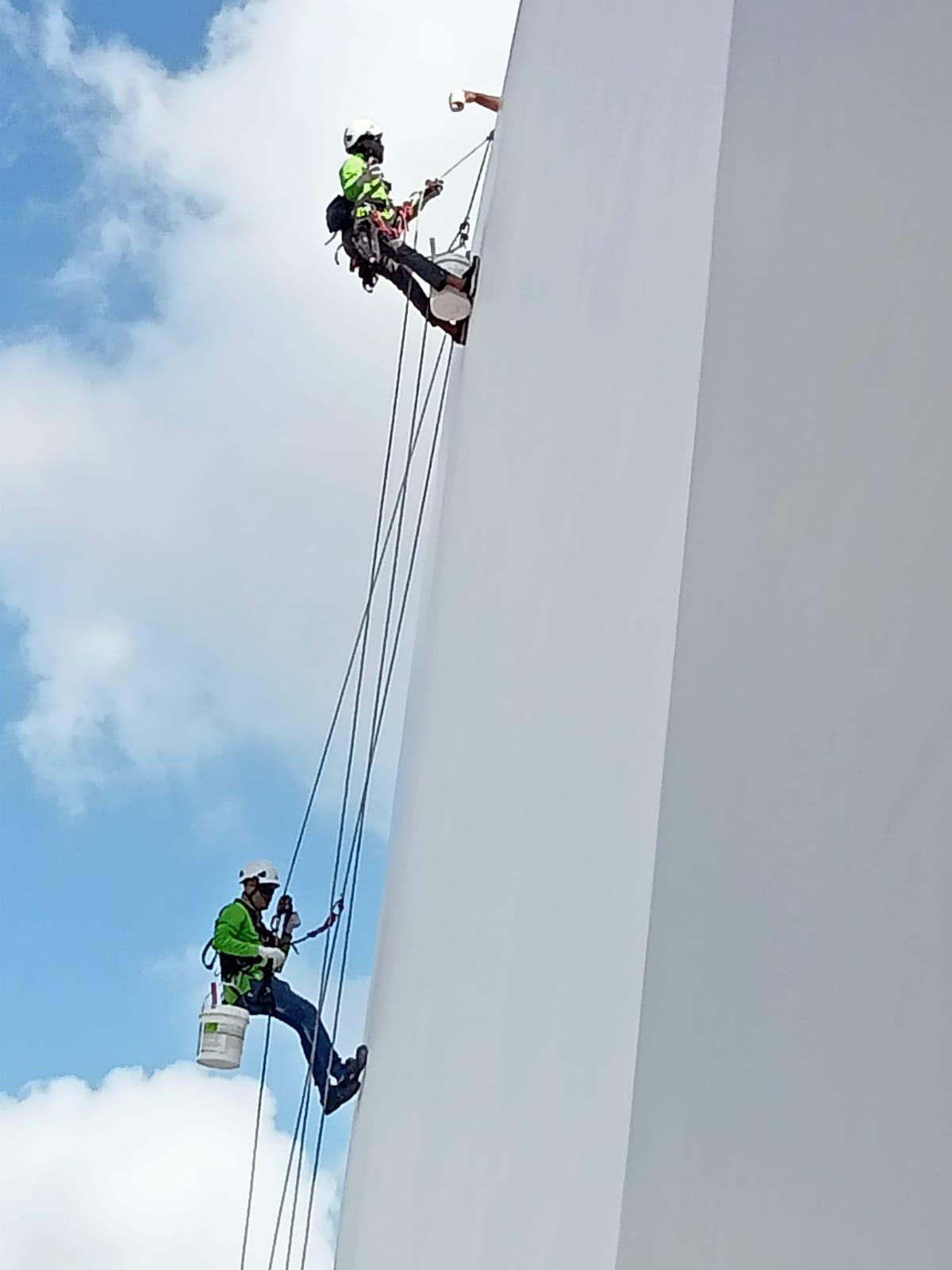 Rope access technician with tool tethering carrying out facade repair on a Singapore HDB residential block