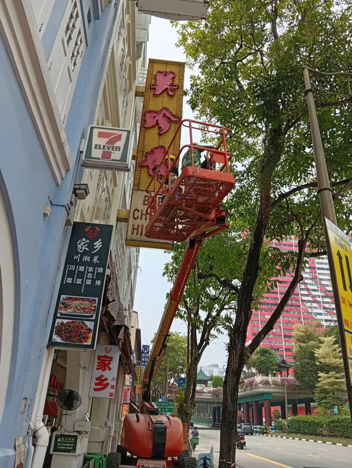 Boomlift raising a worker beside the Bee Cheng Hiang sign during the façade works on New Bridge Road