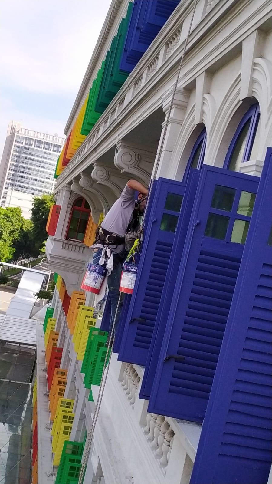 Wider context view of the Old Hill Street Police Station heritage facade with rope access lines visible during the repainting programme