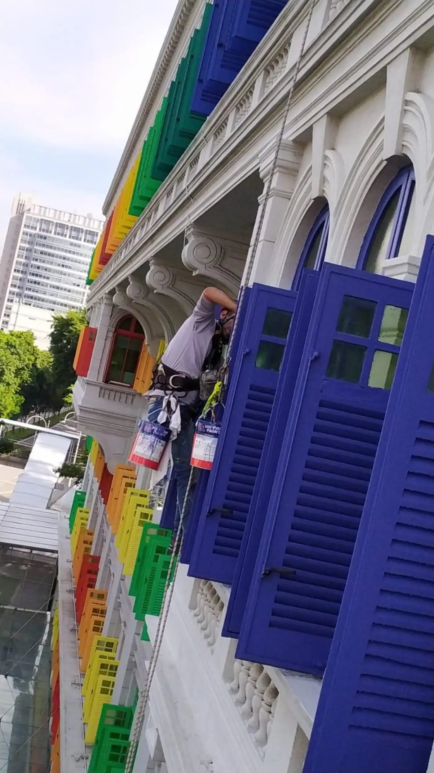 Wider context view of the Old Hill Street Police Station heritage facade with rope access lines visible during the repainting programme
