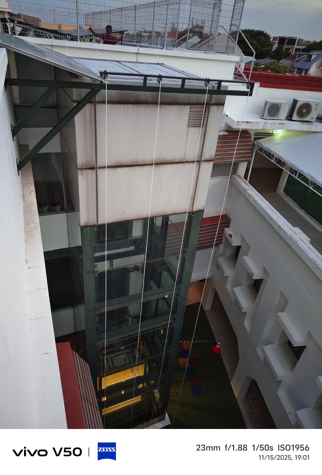 Wider context view of the courtyard around the glass lift shaft and surrounding building elevations during the support-structure installation works