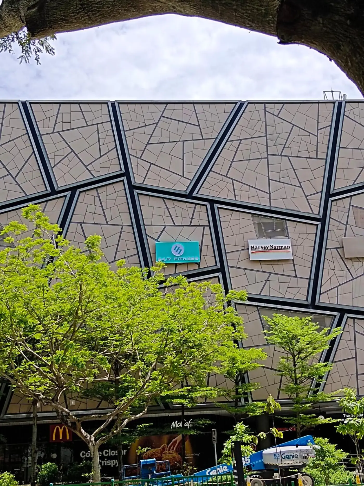 Wider context view of The Seletar Mall facade with the new tenant signage in position and a boomlift visible at the base for coordinated access